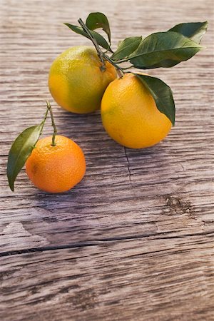 Two oranges and one clementine with leaves Stock Photo - Premium Royalty-Free, Code: 659-01864125