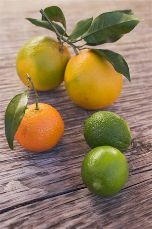 Oranges, clementine and limes on wooden background Stock Photo - Premium Royalty-Free, Code: 659-01864126