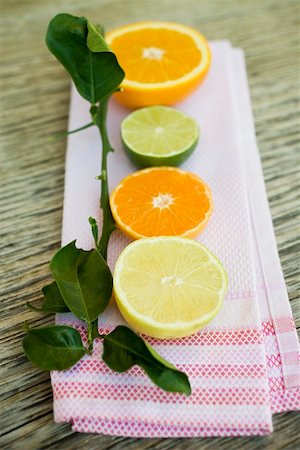 Assorted citrus fruit, halved, with leaves Stock Photo - Premium Royalty-Free, Code: 659-01864147