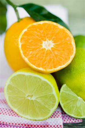 Assorted citrus fruit, whole and halved Fotografie stock - Premium Royalty-Free, Codice: 659-01864151