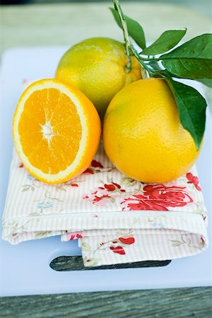 Two oranges with leaves and half a clementine Stock Photo - Premium Royalty-Free, Code: 659-01864153