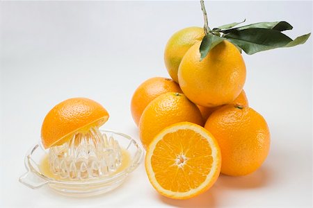 spremiagrumi a mano - Juice oranges with citrus squeezer Fotografie stock - Premium Royalty-Free, Codice: 659-01864186