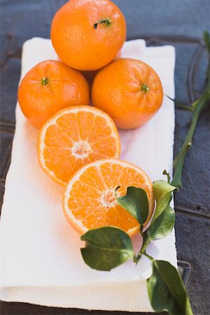 simsearch:659-01864171,k - Whole and half clementines on white cloth, with leaves Foto de stock - Sin royalties Premium, Código: 659-01864183