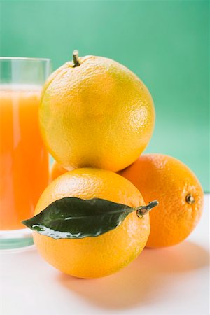 simsearch:659-01853891,k - Glass of orange juice beside several oranges Foto de stock - Sin royalties Premium, Código: 659-01864209