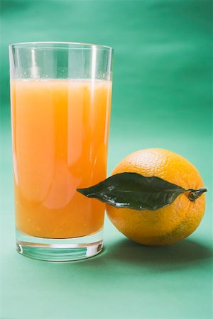 simsearch:659-01864200,k - Glass of orange juice beside orange with leaf Foto de stock - Sin royalties Premium, Código: 659-01864211