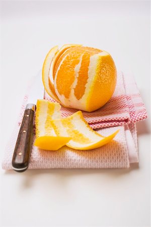 Peeled orange on tea towel with knife Foto de stock - Sin royalties Premium, Código: 659-01864220