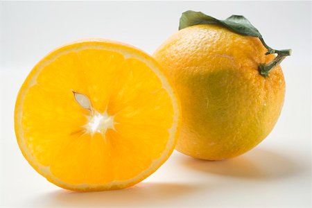 set up - Slice of orange in front of whole orange Stock Photo - Premium Royalty-Free, Code: 659-01864244