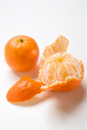 Two clementines (peeled and unpeeled) Fotografie stock - Premium Royalty-Free, Codice: 659-01864241