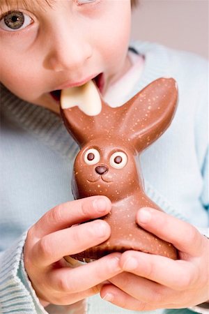 Enfant mordre dans le lapin de Pâques au chocolat Photographie de stock - Premium Libres de Droits, Code: 659-01864302