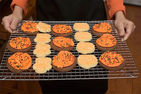 simsearch:659-01861766,k - Hands holding Halloween biscuits on cake rack Fotografie stock - Premium Royalty-Free, Codice: 659-01864399