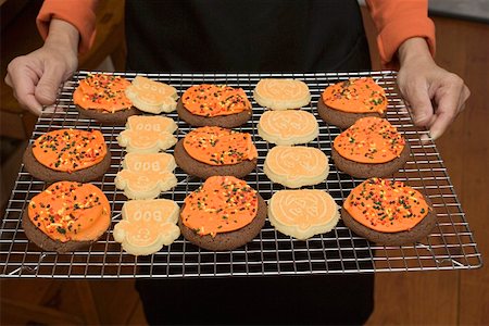 simsearch:659-03526122,k - Hands holding Halloween biscuits on cake rack Foto de stock - Sin royalties Premium, Código: 659-01864399