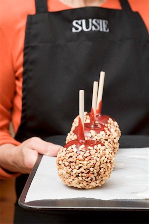 simsearch:659-02213327,k - Woman holding a tray of toffee apples with chopped nuts Foto de stock - Sin royalties Premium, Código: 659-01864413