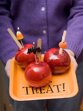 Woman holding tray of toffee apples for Halloween Stock Photo - Premium Royalty-Free, Code: 659-01864584