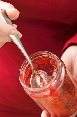 Woman holding almost empty jar of strawberry jam Stock Photo - Premium Royalty-Free, Code: 659-01864599