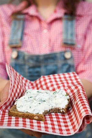 Woman holding wholemeal bread with quark & ramsons on napkin Stock Photo - Premium Royalty-Free, Code: 659-01864609