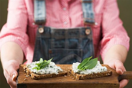 sandwich spread - Person holding wholemeal bread with quark & ramsons on board Stock Photo - Premium Royalty-Free, Code: 659-01864601