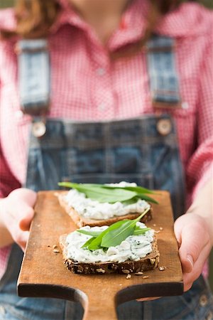 Person holding wholemeal bread with quark & ramsons on board Fotografie stock - Premium Royalty-Free, Codice: 659-01864602