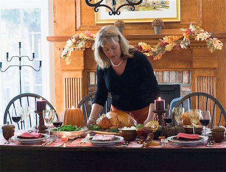 Woman serving stuffed turkey for Thanksgiving (USA) Stock Photo - Premium Royalty-Free, Code: 659-01864745