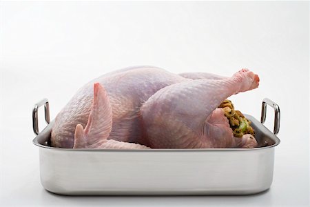 plucked - Raw stuffed turkey in roasting tin Foto de stock - Sin royalties Premium, Código: 659-01864887