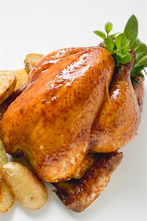 roast chicken top view - Whole roast chicken with herbs and potatoes Stock Photo - Premium Royalty-Free, Code: 659-01864949