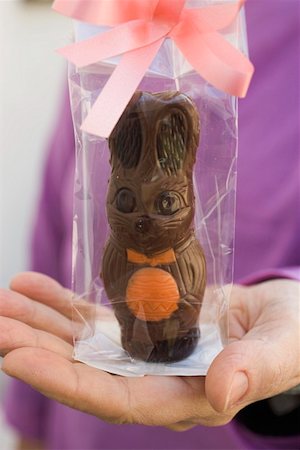 simsearch:659-01865781,k - Hand holding gift-wrapped chocolate Easter Bunny Foto de stock - Sin royalties Premium, Código: 659-01864995