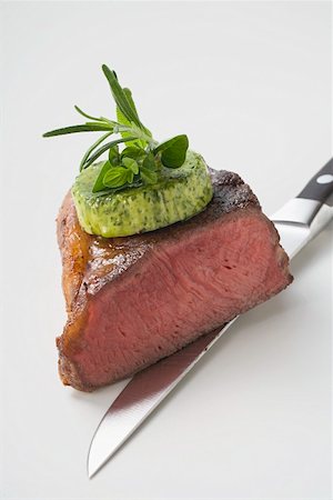 simsearch:659-01845777,k - Beef steak with herb butter on knife (showing cut edge) Foto de stock - Sin royalties Premium, Código: 659-01865241