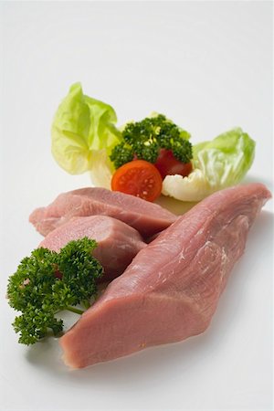 pork fillets - Pork fillet with parsley, tomato and lettuce leaf Stock Photo - Premium Royalty-Free, Code: 659-01865301