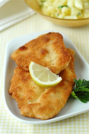 Breaded chicken escalopes, potato salad in background Stock Photo - Premium Royalty-Free, Code: 659-01865320