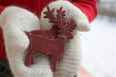 simsearch:659-03529405,k - Hands in mittens holding two reindeer (Christmas decorations) Fotografie stock - Premium Royalty-Free, Codice: 659-01865334