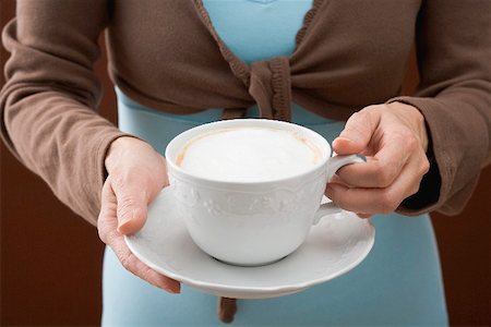 simsearch:659-01863847,k - Woman holding cup of cappuccino Fotografie stock - Premium Royalty-Free, Codice: 659-01865394