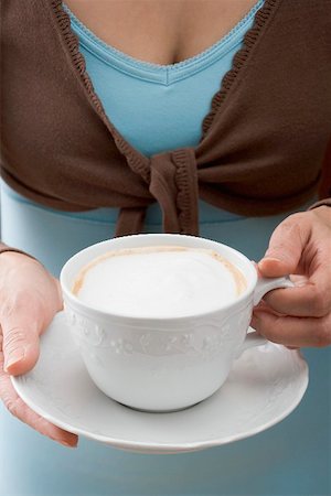 simsearch:659-01863847,k - Woman holding cup of cappuccino Fotografie stock - Premium Royalty-Free, Codice: 659-01865393