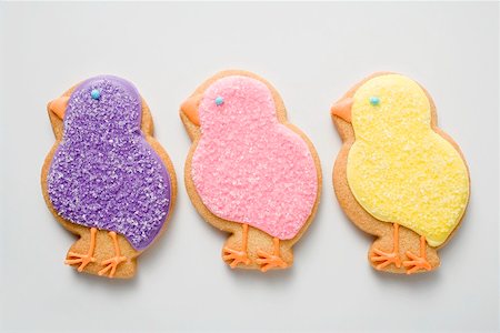 Three Easter biscuits (purple, pink, yellow chicks) Stock Photo - Premium Royalty-Free, Code: 659-01865450