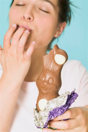 Femme tenant un lapin de Pâques au chocolat avec une morsure prise Photographie de stock - Premium Libres de Droits, Code: 659-01865513