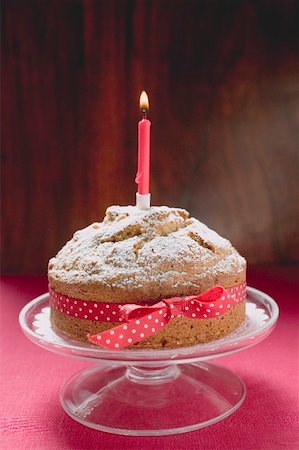 simsearch:659-01846253,k - Birthday cake with red bow and burning candle Stock Photo - Premium Royalty-Free, Code: 659-01865705