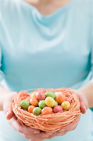 easter eggs candy - Woman holding Easter nest full of coloured sugar eggs Stock Photo - Premium Royalty-Free, Code: 659-01865761