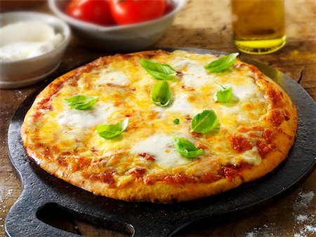 Tomato and mozzarella pizza with basil Stock Photo - Premium Royalty-Free, Code: 659-01866055