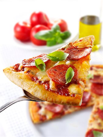 pepperonisalami - Stück Salami Pizza auf server Stockbilder - Premium RF Lizenzfrei, Bildnummer: 659-01866073