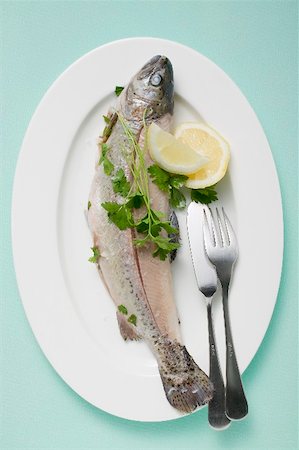 Trout with parsley, lemon wedges & fish knife & fork on plate Stock Photo - Premium Royalty-Free, Code: 659-01866365