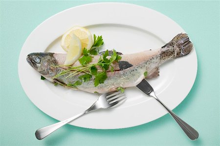 Trout with parsley, lemon and fish knife and fork on plate Stock Photo - Premium Royalty-Free, Code: 659-01866367