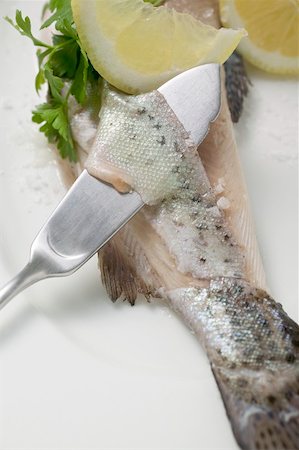 Removing trout skin with a fish knife Stock Photo - Premium Royalty-Free, Code: 659-01866368