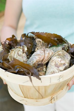 Woman holding basket full of fresh oysters Stock Photo - Premium Royalty-Free, Code: 659-01866375