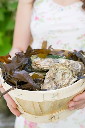 Woman holding basket full of fresh oysters Stock Photo - Premium Royalty-Free, Code: 659-01866377