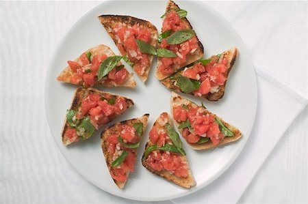 Bruschetta with tomato salsa and basil on plate Stock Photo - Premium Royalty-Free, Code: 659-01866456