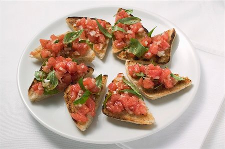 Bruschetta with tomato salsa and basil on plate Stock Photo - Premium Royalty-Free, Code: 659-01866457