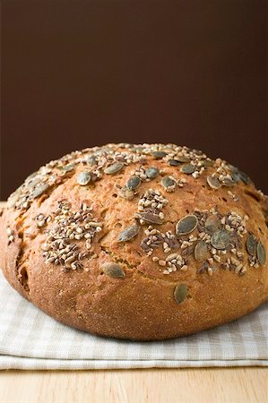 simsearch:659-01866647,k - Wholemeal bread with pumpkin seeds on tea towel Foto de stock - Royalty Free Premium, Número: 659-01866622