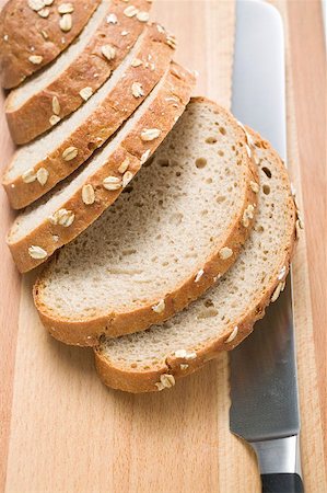 simsearch:659-01866634,k - Oat bread, sliced, on chopping board with bread knife Foto de stock - Sin royalties Premium, Código: 659-01866643