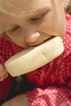 Small girl eating an ice cream on a stick Foto de stock - Sin royalties Premium, Código: 659-01866686