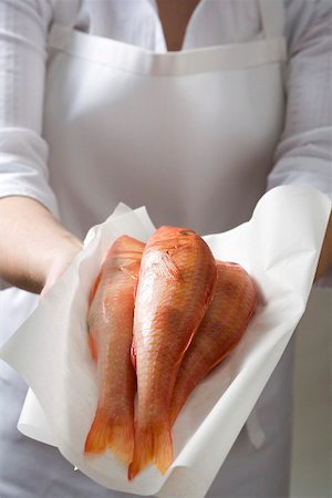 Woman holding fresh red mullet on paper Stock Photo - Premium Royalty-Free, Code: 659-01866808