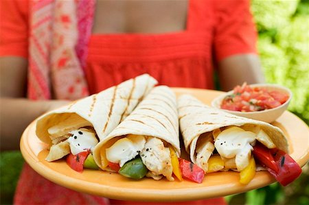 simsearch:659-03527105,k - Woman holding plate of wraps and salsa Foto de stock - Royalty Free Premium, Número: 659-01866927