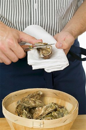 raw oyster - Man opening a fresh oyster Stock Photo - Premium Royalty-Free, Code: 659-01867098